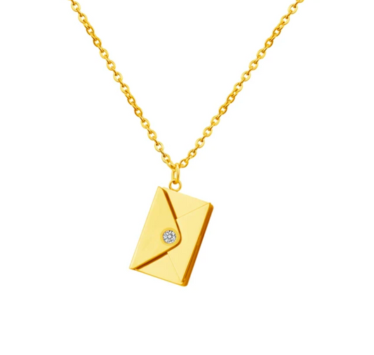 Gold necklace with a diamond-studded envelope pendant on a white background